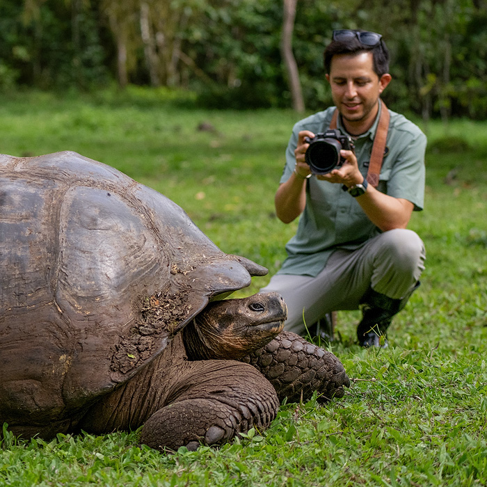 Image showing Lucas Bustamante photographing a giant tortoise